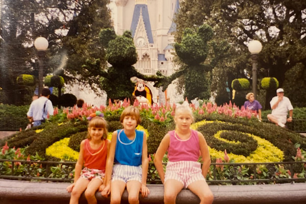 Three kids sit in the Magic Kingdom hub in 1993