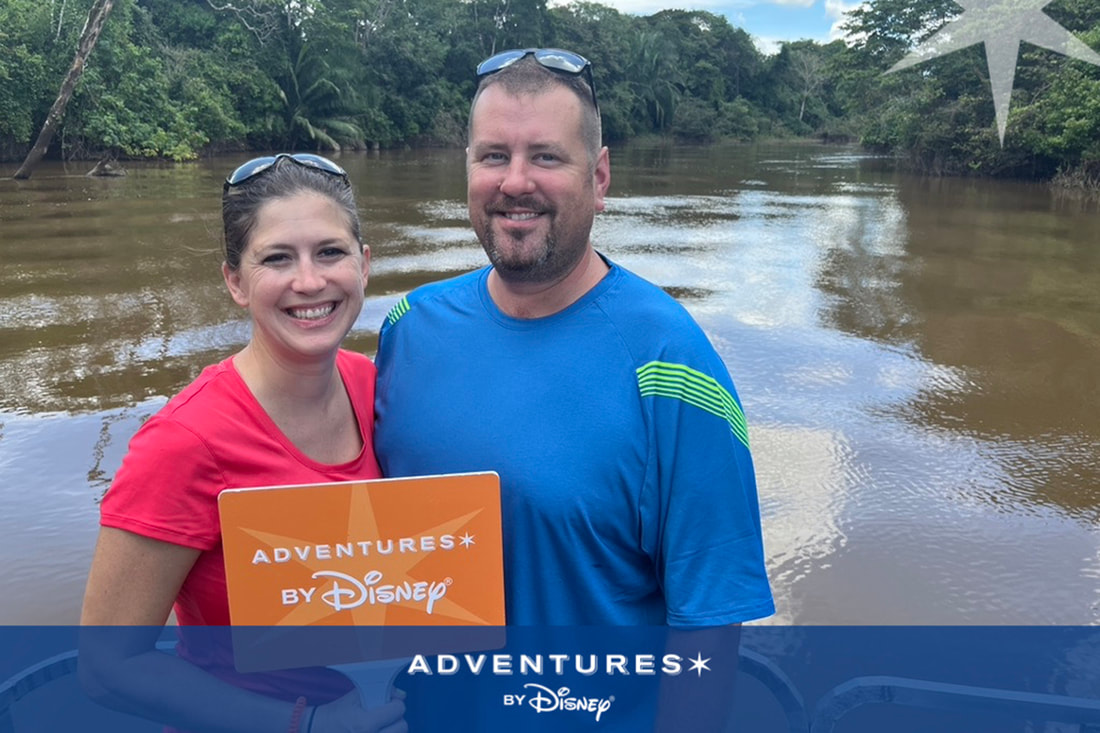 A couple poses with an Adventures by Disney sign in Costa Rica